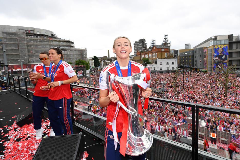 Chloe Kelly of Arsenal holding the UEFA Women's Champions League trophy at a celebratory parade.
