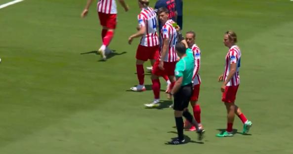 Soccer players and a referee on a field.