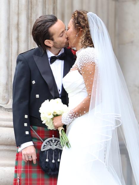 Mel B and her husband kissing after their wedding at St. Paul's Cathedral.
