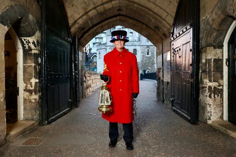 A Yeoman Warder at the Tower of London holding keys and a lantern.