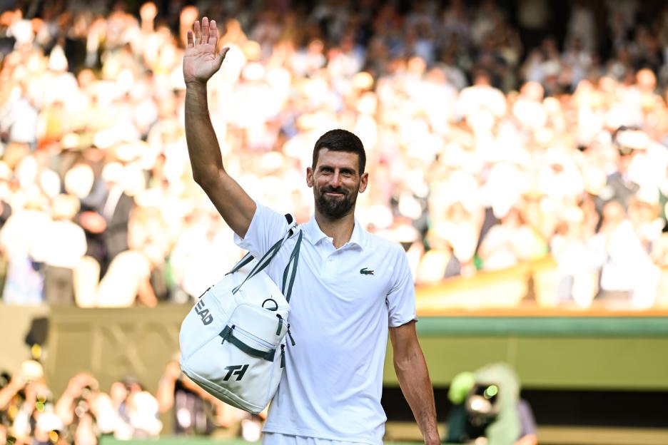Novak Djokovic waving to the crowd after a Wimbledon match.