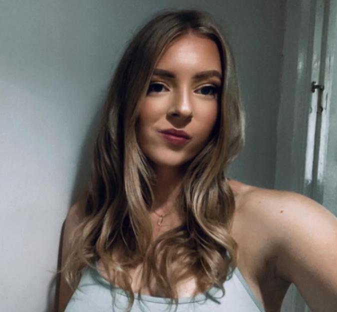 Lauren Jarvis, a woman with long wavy blonde hair, wearing a light-blue tank top.