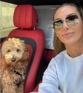 Sara King and her dog in a red car.