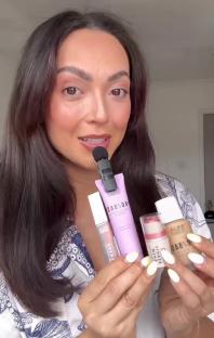 Woman shows makeup products.