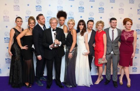 Group photo of a cast and crew at an awards ceremony.