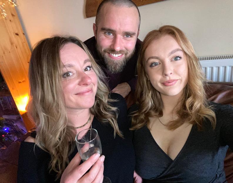 A woman and two younger people smiling for a photo.