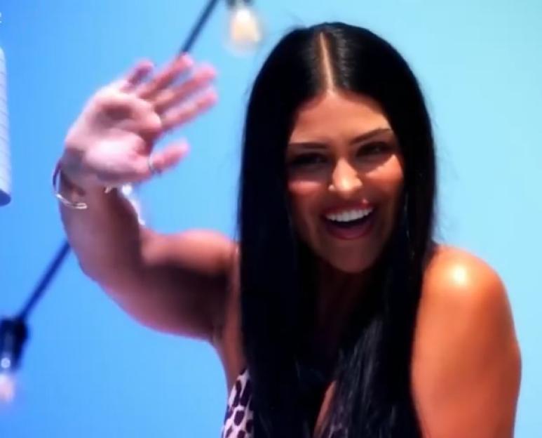 Screenshot of a woman waving.