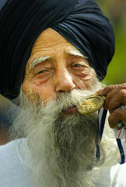 Fauja Singh, 94, holding his medal after finishing the Edinburgh Marathon.