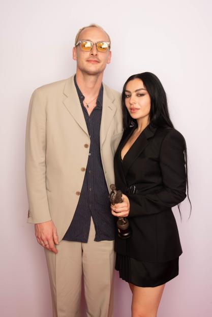 George Daniel and Charli XCX posing with the Visionary Award at the Ivor Novello Awards.