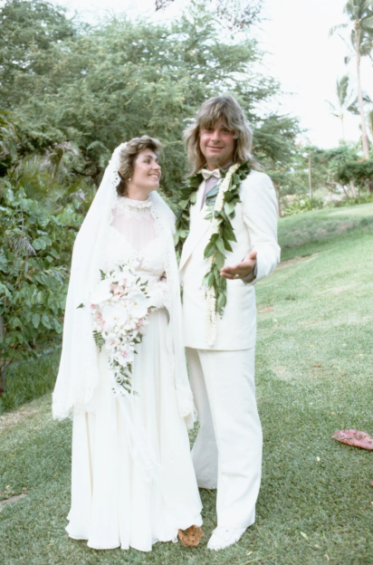 A bride and groom in white wedding attire on their wedding day.