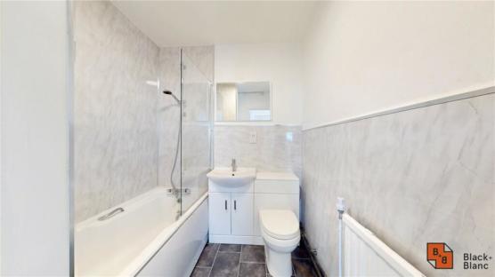 Bathroom with bathtub, sink, toilet, and shower.