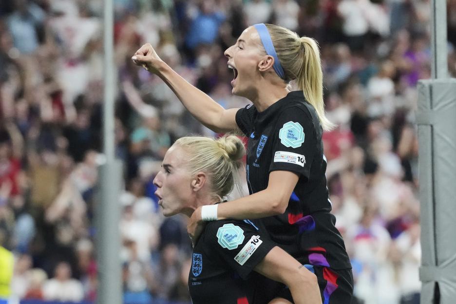 Chloe Kelly celebrates on Alex Greenwood's back after England scores.