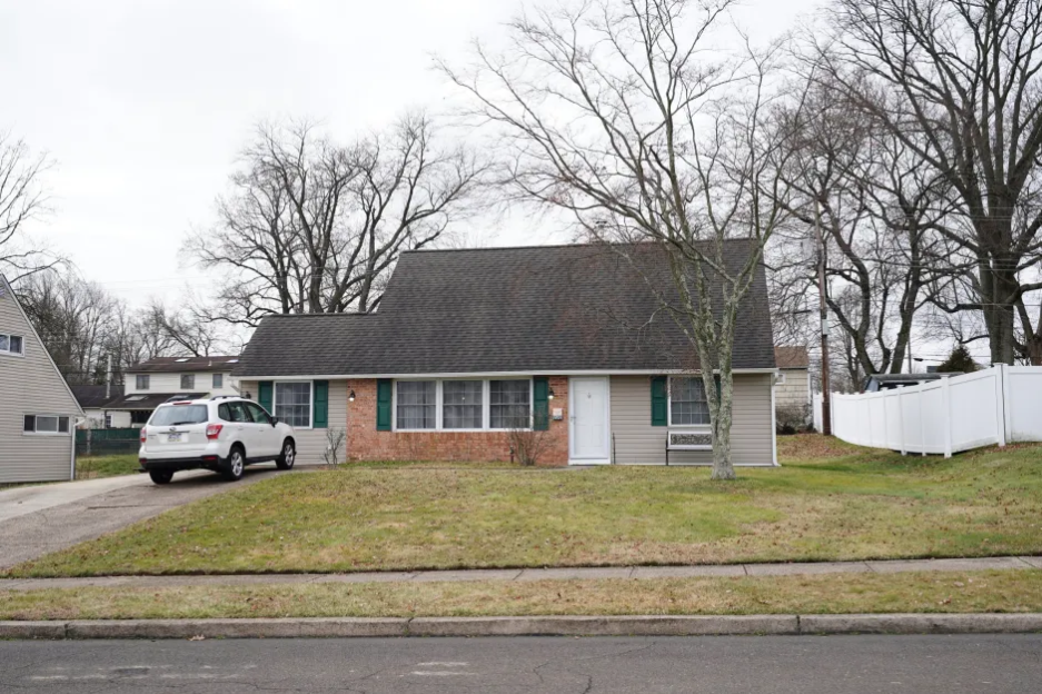 Ranch house with a white car parked in the driveway.