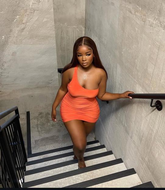 Woman in orange dress descending stairs.