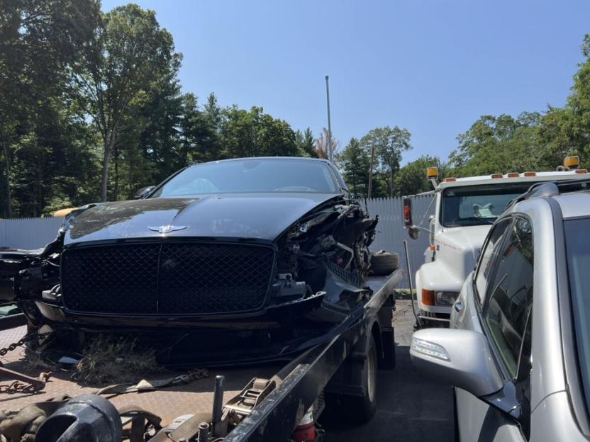 Damaged Bentley on a tow truck.