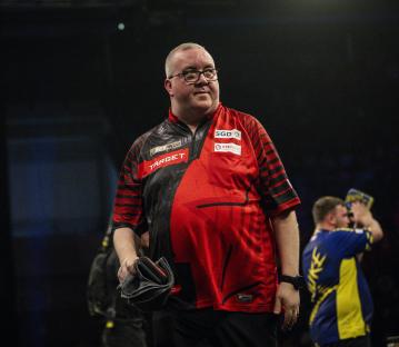 Stephen Bunting walks off stage after a darts match.