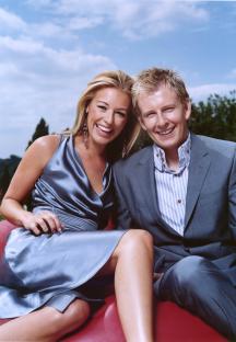 a woman in a blue dress sits next to a man in a suit