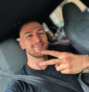 Man in a car making a peace sign.