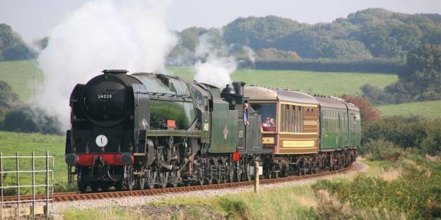 Steam train traveling through the countryside.