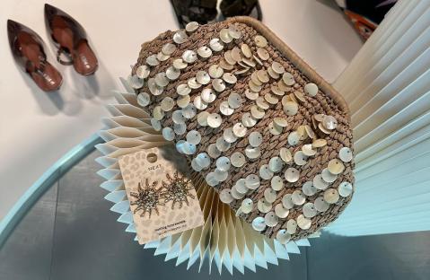 Straw bag with shell embellishments, sandals, and earrings.
