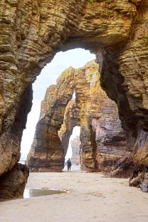 Couple walking on Praia As Catedrais beach in Spain.