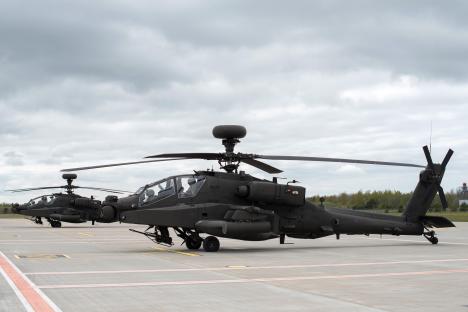 Two British Army Apache attack helicopters on a tarmac.