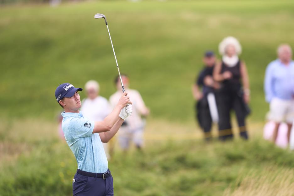 Maverick McNealy taking a golf shot.
