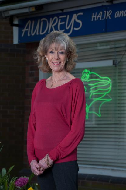 Sue Nicholls, who plays Audrey Roberts in Coronation Street, standing outside Audrey's hair salon.