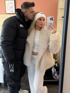 A couple taking a selfie in a hotel room.