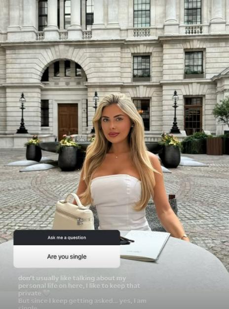 Woman in white dress answering a question about her relationship status.
