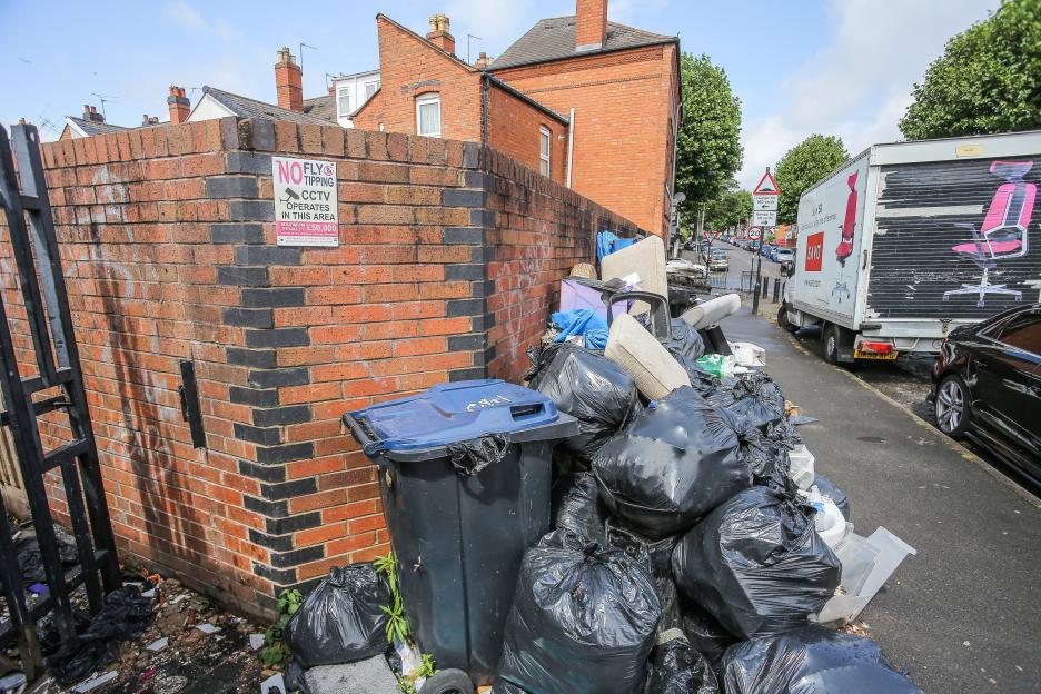 Overflowing trash bags and refuse piled on a Birmingham street during a bin strike.