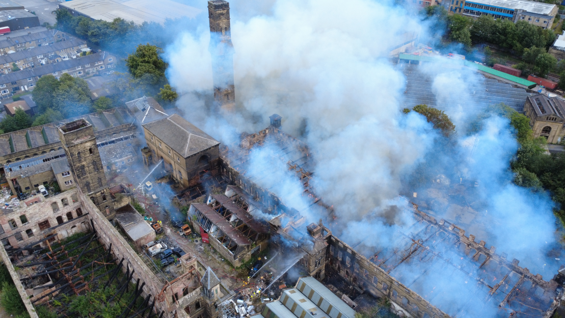 Aerial view of a large building fire with heavy smoke.