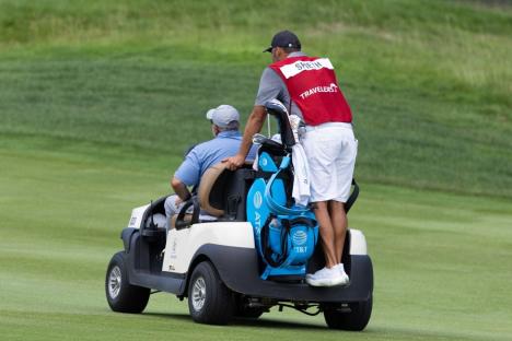 Golfer and caddie on a golf cart.