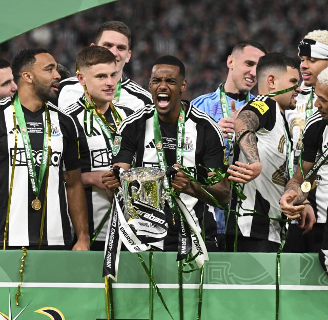 Newcastle United players celebrating with the EFL Cup trophy.