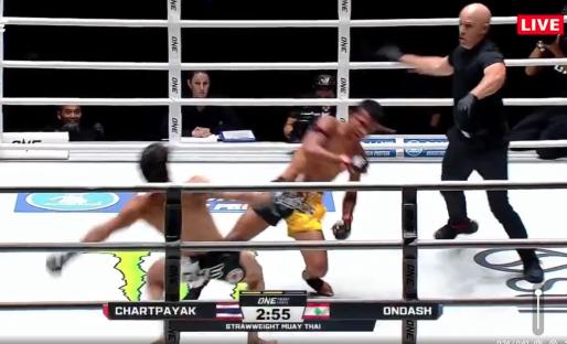 Muay Thai match; one fighter falls to the mat as the referee watches.