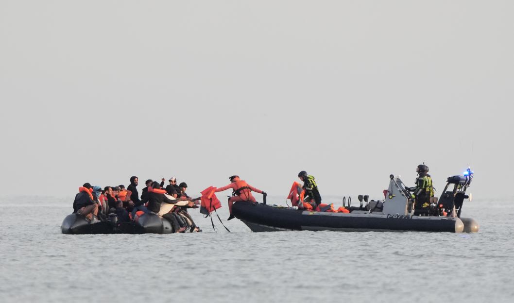 Life jackets being transferred from a rescue boat to a small boat carrying migrants.