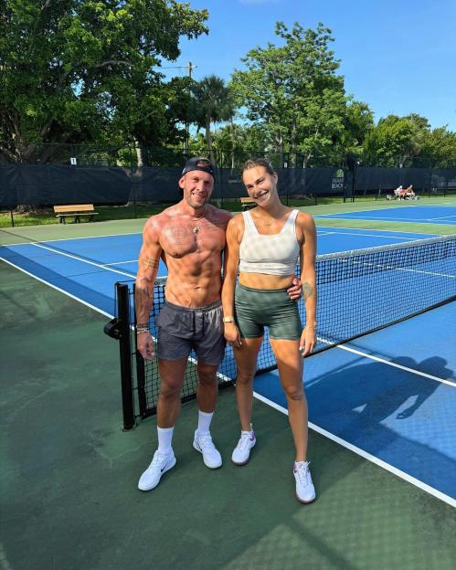 Aryna Sabalenka and Georgios Frangulis on a tennis court.