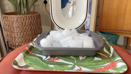 Ice cubes in a baking dish on a tray.