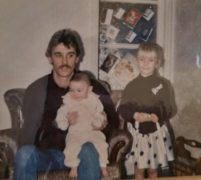 Photo of a father with his two young children.