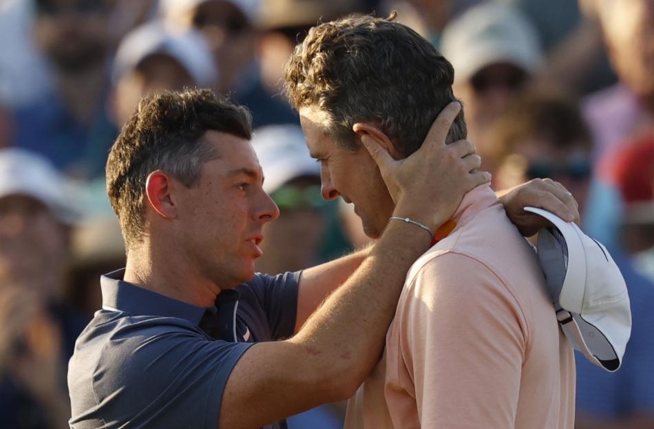Rory McIlroy and Justin Rose embrace after a golf tournament.