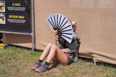 Festivalgoer using a hand fan to cool down.