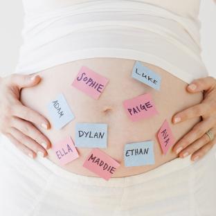 a pregnant woman holds her belly with sticky notes on it