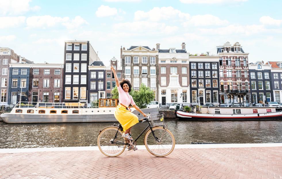 Woman joyfully cycling in Amsterdam.