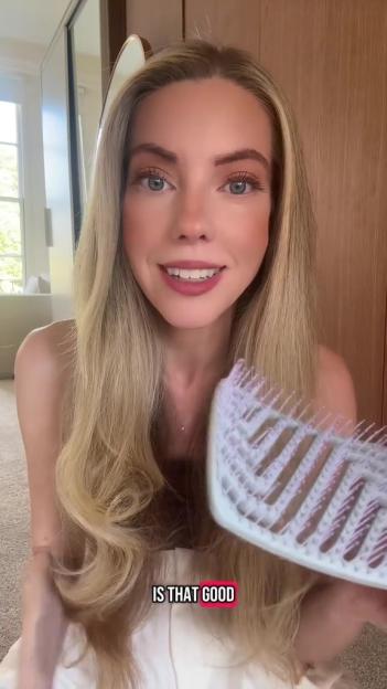 Woman reviewing a hairbrush.