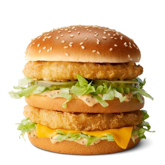 a hamburger with lettuce and cheese on a bun with sesame seeds