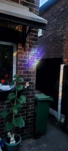 Multicolored string lights hanging outside a house.