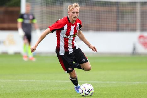 Brentford B player Max Dickov dribbling the ball.