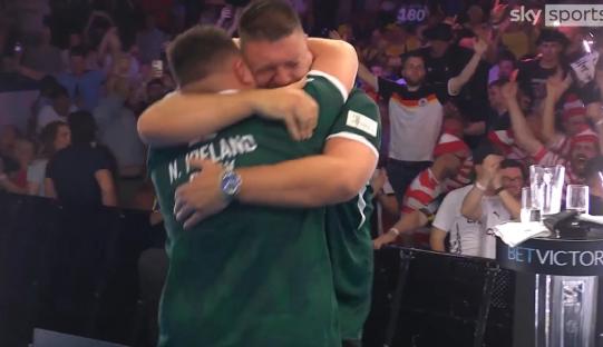 Daryl Gurney and Josh Rock embrace after a darts win.