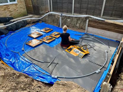 Person installing interlocking tiles for a pool.