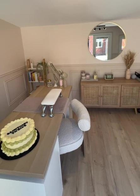Nail salon interior with manicure station, cake, and storage unit.